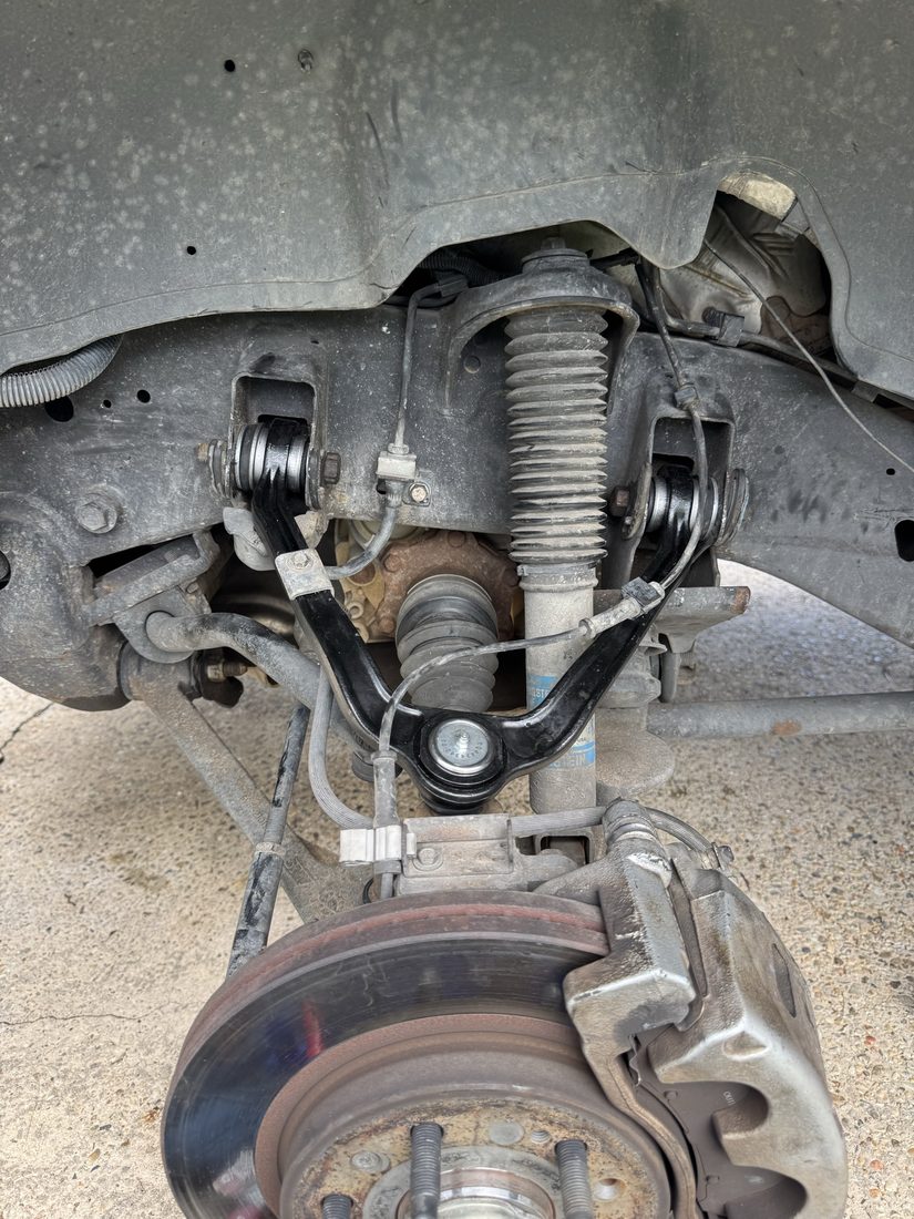 Front suspension showing a new upper control arm and ball joint